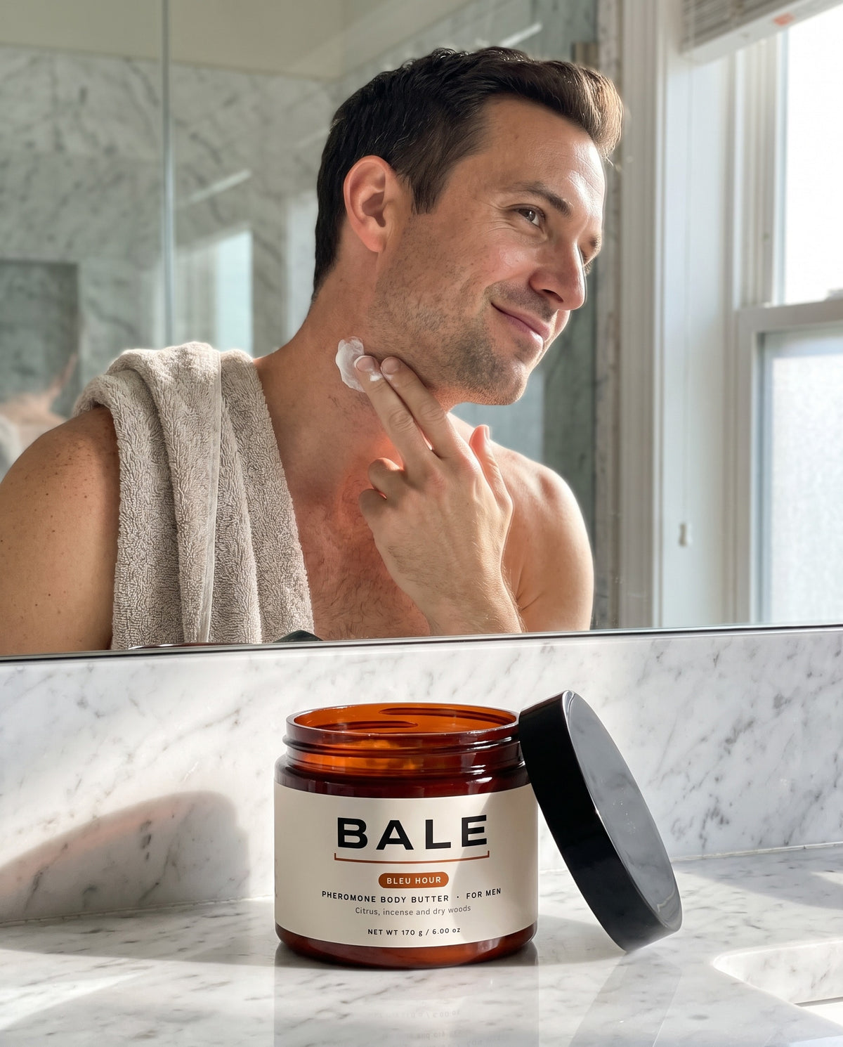 A man applying Bleu Hour body butter in a bright bathroom