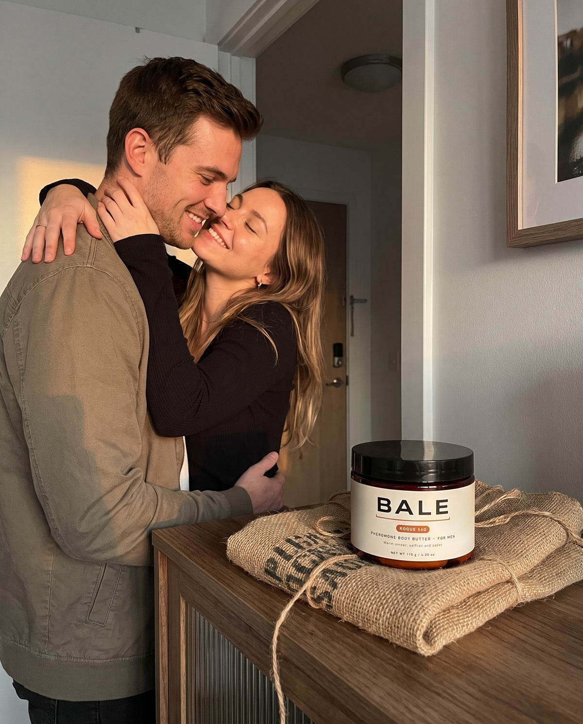 She leans in close to him, the Rogue 540 jar on the console table