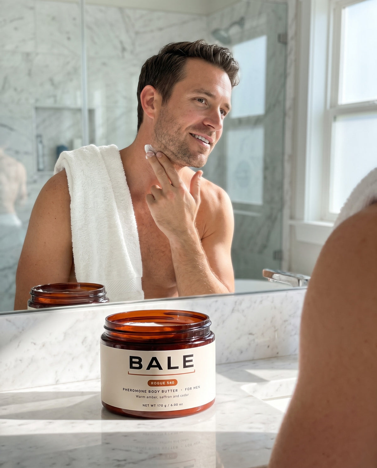 A man applying Rogue 540 body butter in a bright bathroom