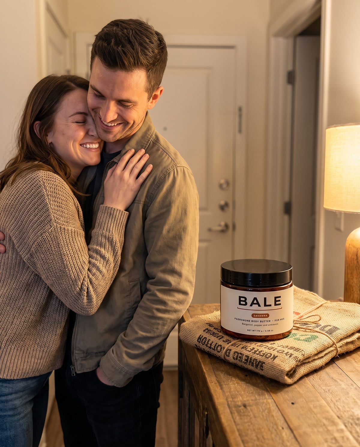She leans in close to him, the Savanna jar on the console table