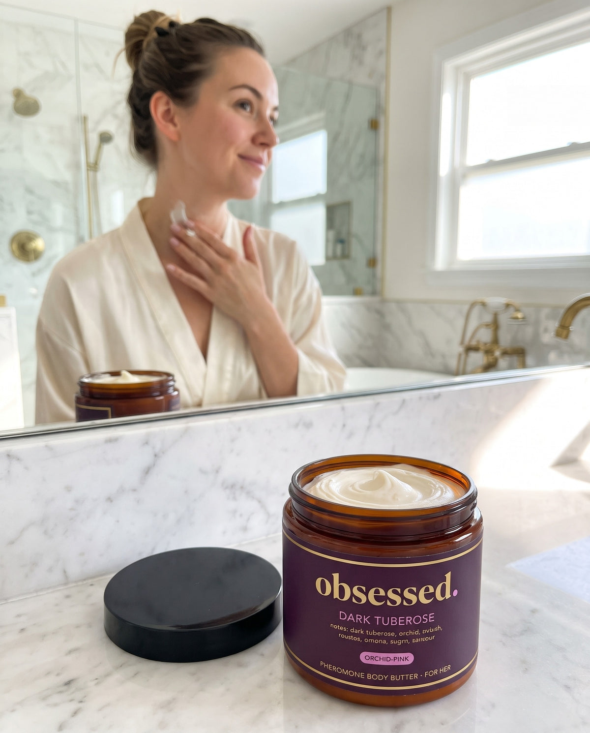 A woman smoothing Dark Tuberose body butter along her collarbone and neck