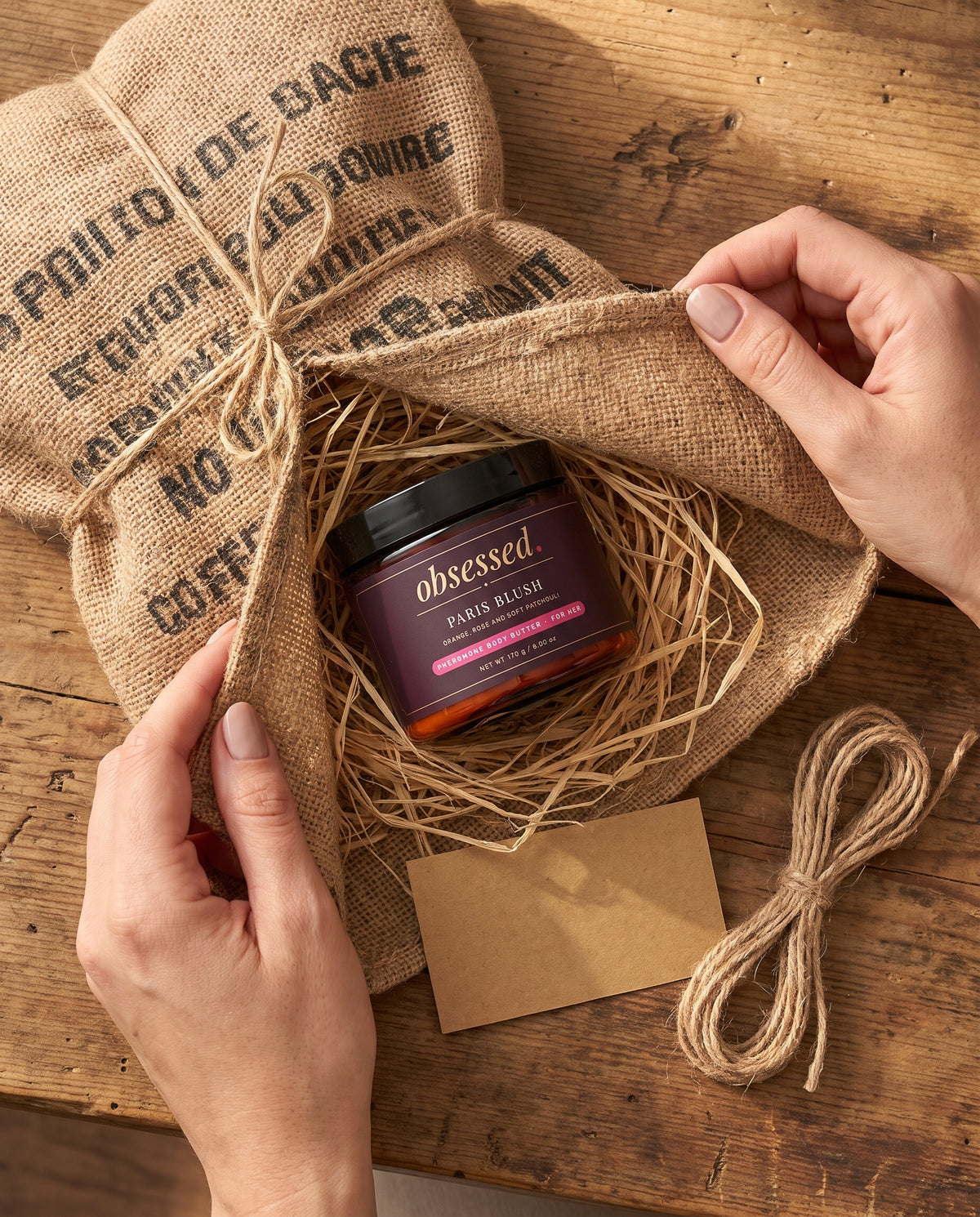 Hands unfold the coffee sack wrap to reveal the Paris Blush jar and a kraft card