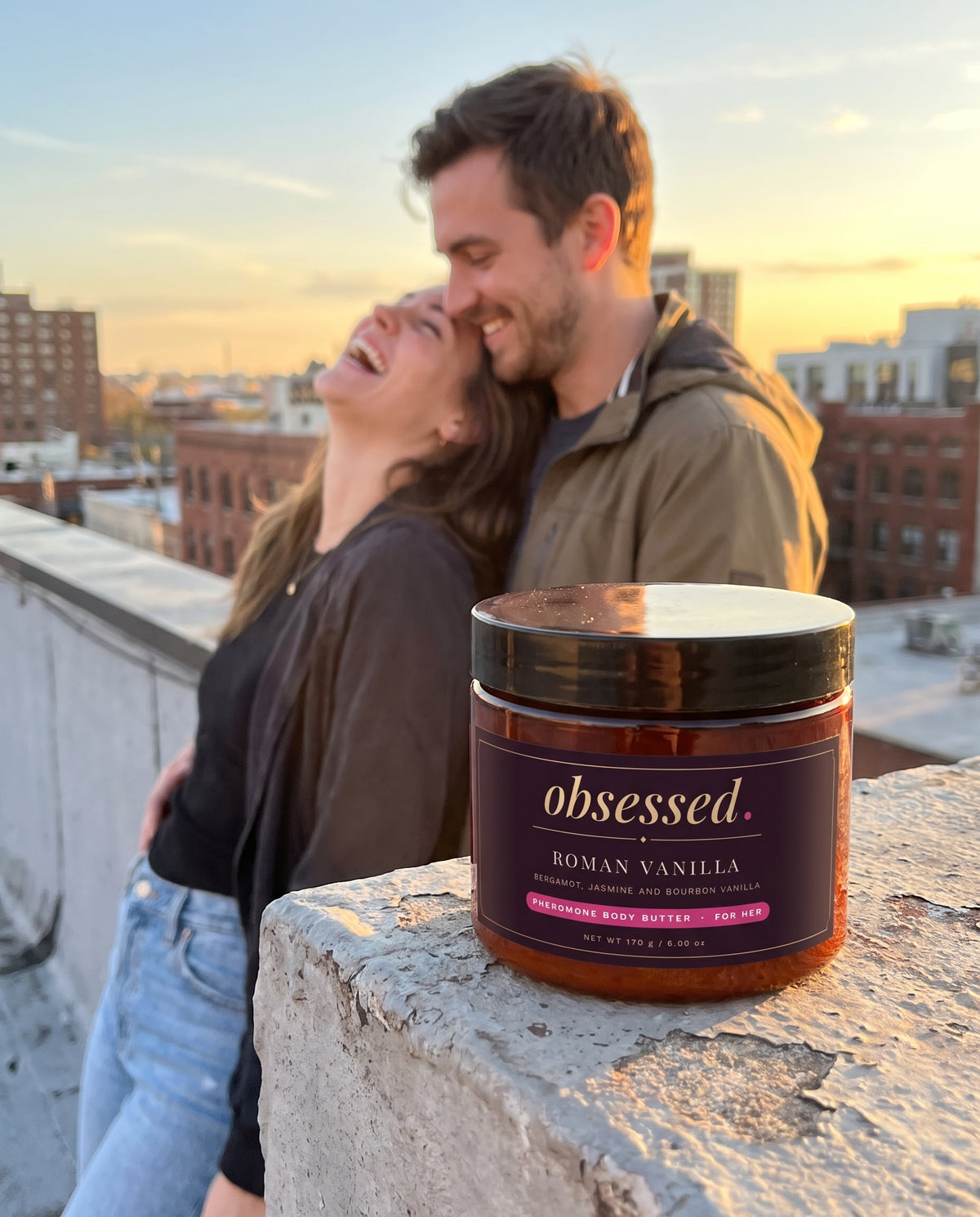 A couple on a rooftop at golden hour, the Roman Vanilla jar on the ledge
