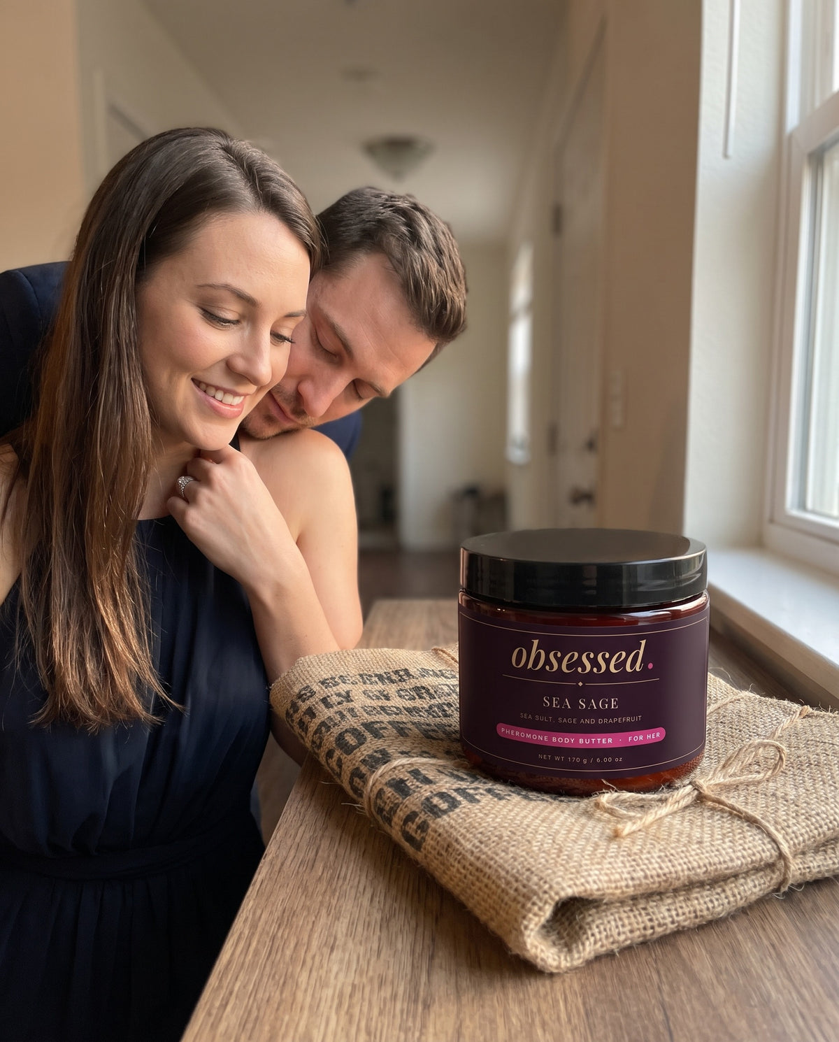 Her partner leans in close, the Sea Sage jar on the console table beside them
