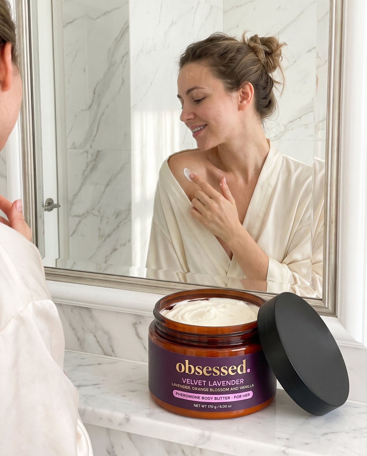 A woman smoothing Velvet Lavender body butter along her collarbone and neck